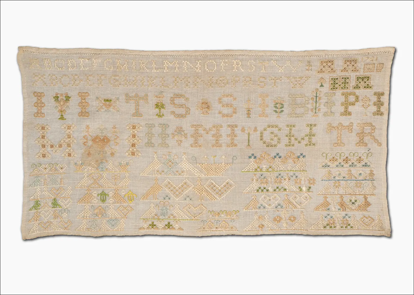 Ein Stickmustertuch mit gestickten Buchstaben und Motiven.