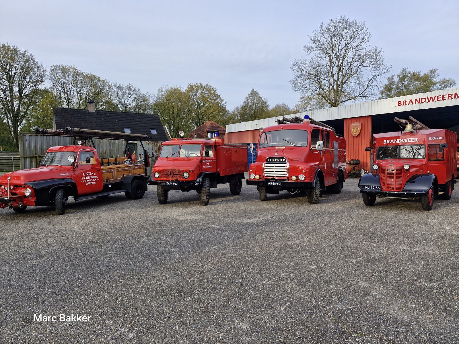 Plusieurs camions de pompiers rouges sur le terrain extérieur devant le hall du musée.