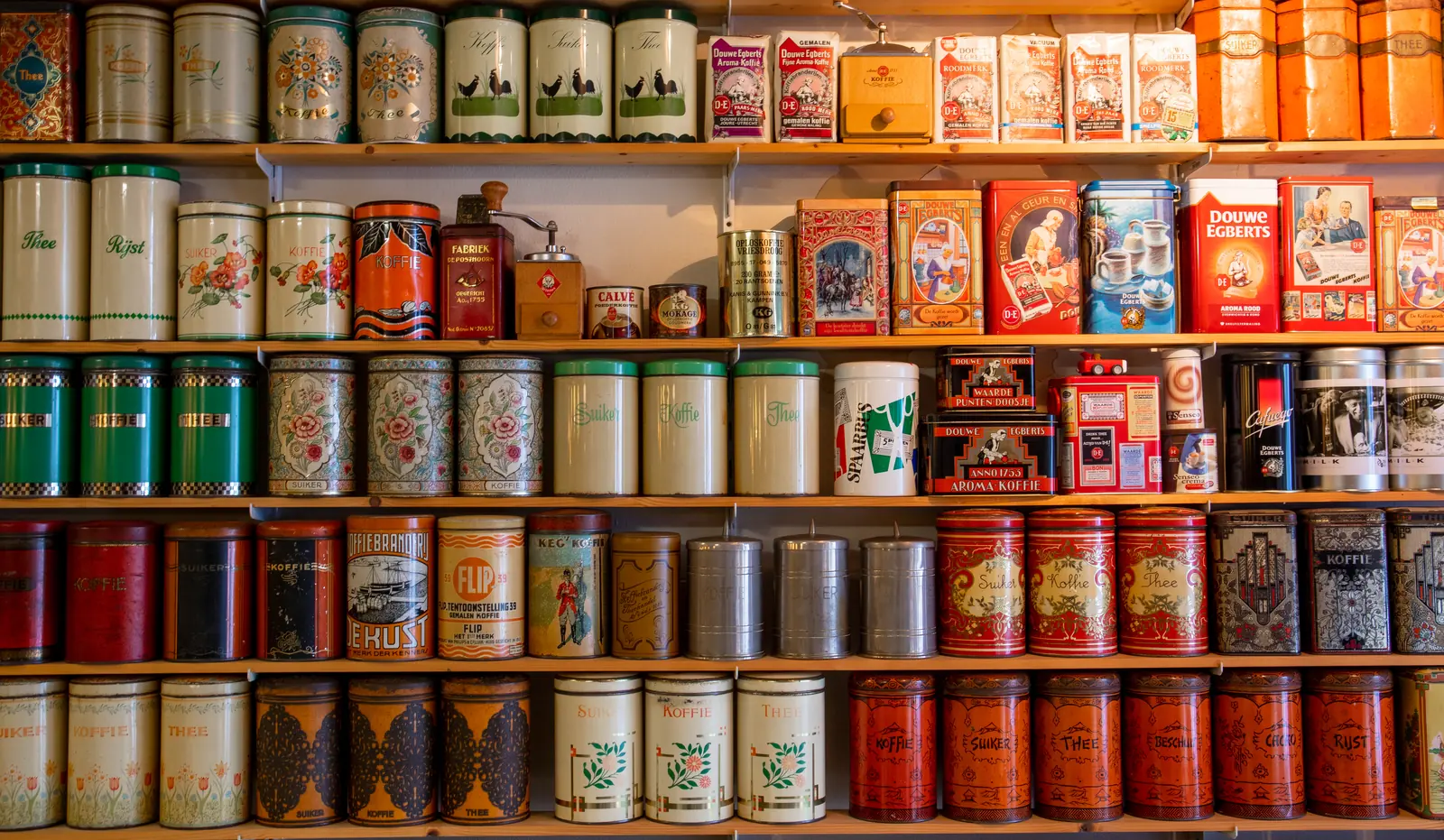 Un mur de boîtes colorées alignées sur des étagères en bois.