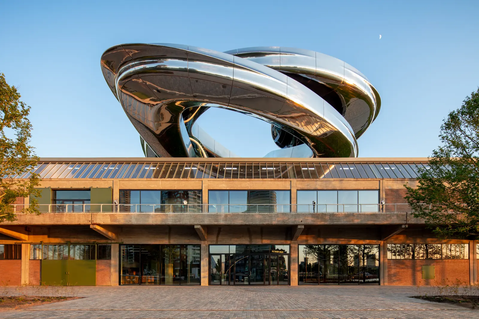 Het museumgebouw Fenix met op het dak een glanzende, spiraalvormige trap van staal, de Tornado.