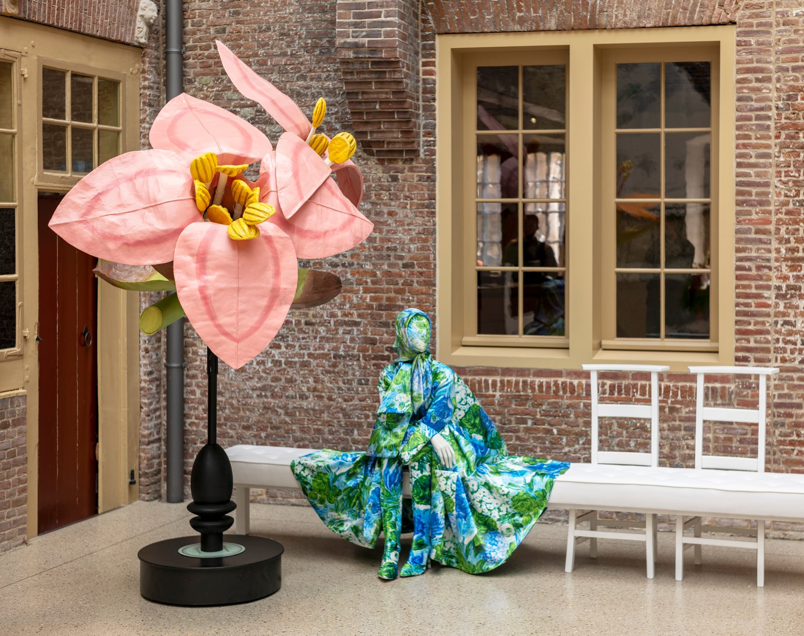 Grande fleur rose et silhouette de mode dans l’exposition Tuin der lusten au Museum De Lakenhal.