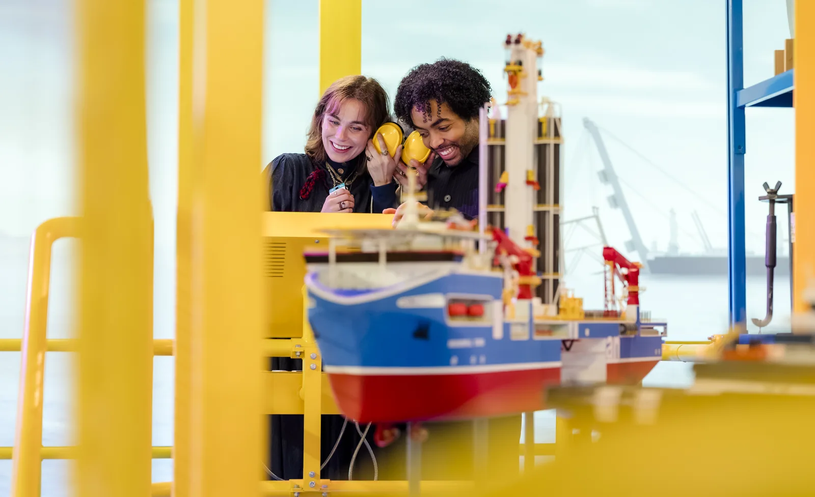Twee bezoekers bekijken een model van een werkschip in de Offshore Experience.