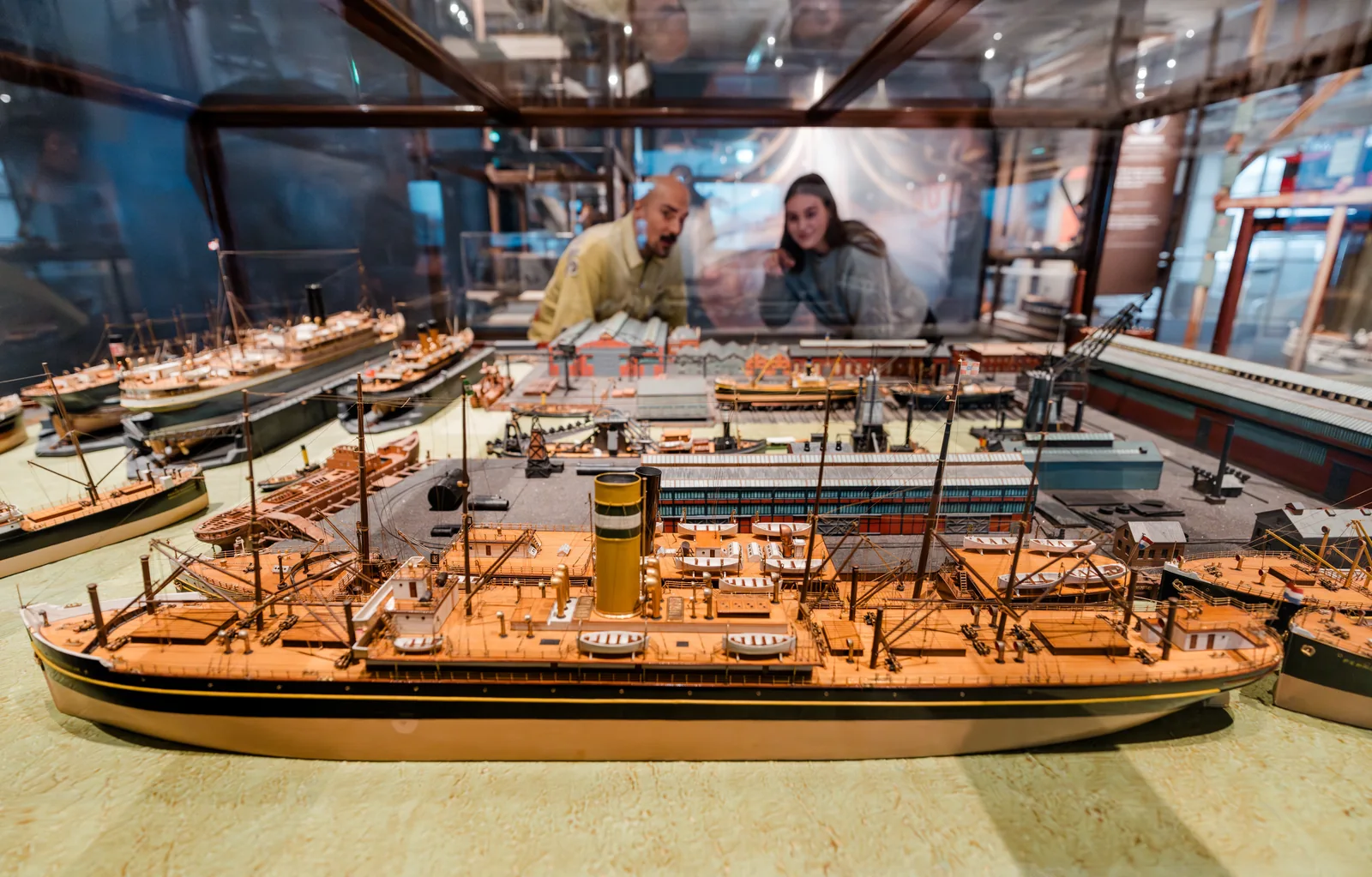 Twee bezoekers bekijken een grote scheepswerfmaquette in Te Water!