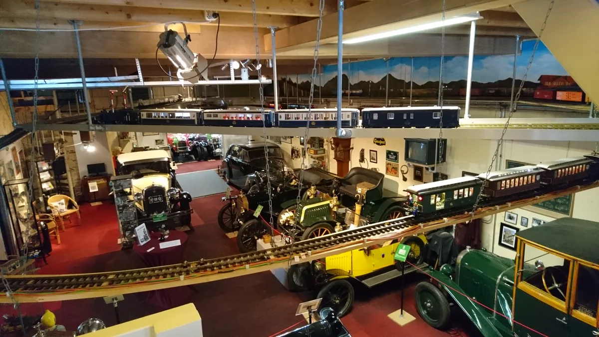 Overzicht van de museumzaal met voertuigen en modeltreinen.