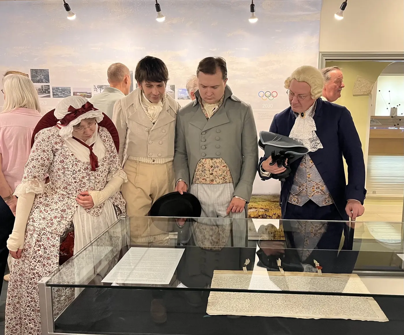 Visitors looking together into a display case at Museum Heerenveen.