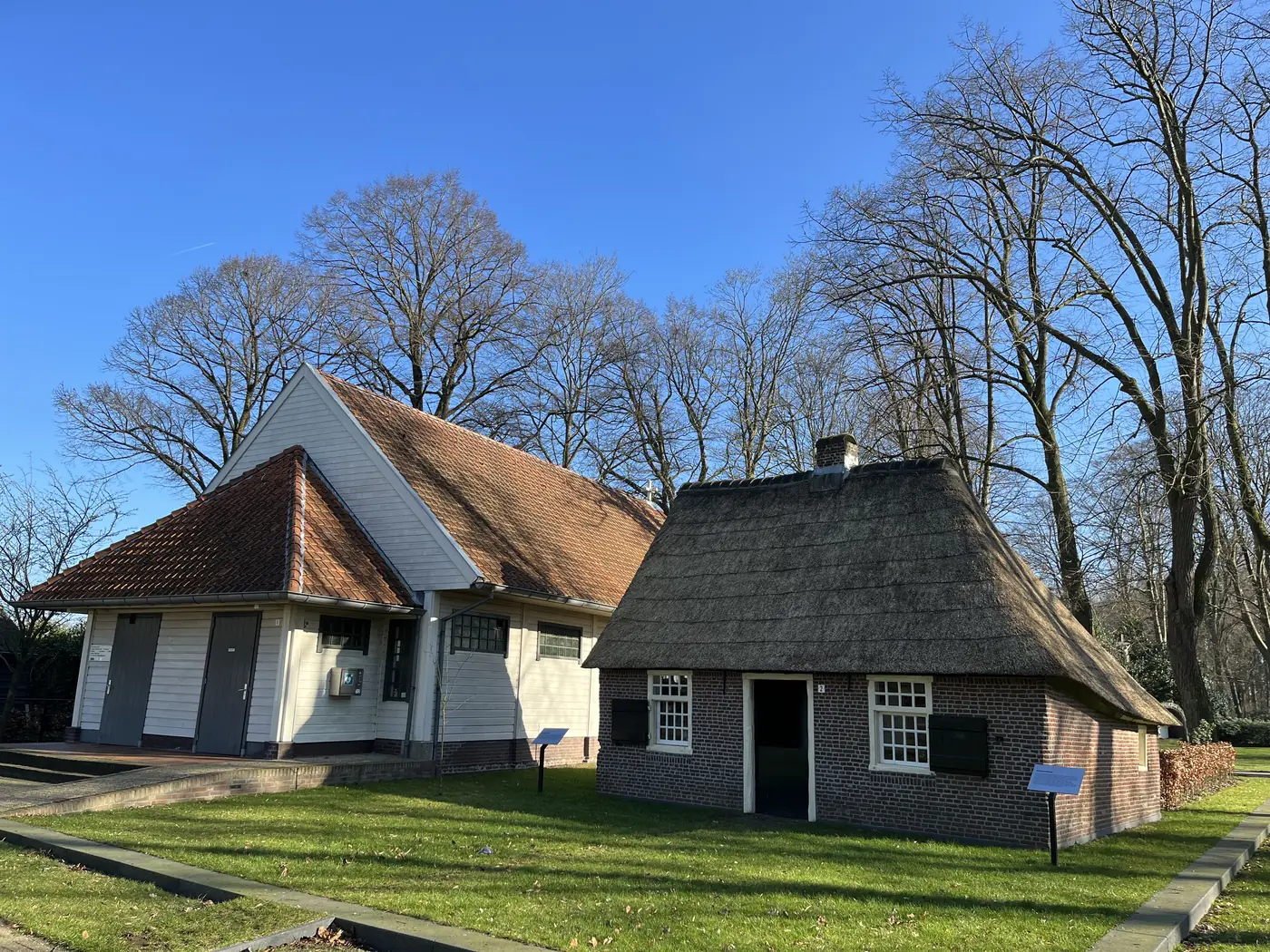 Réplique d’une maison natale basse sous un ciel bleu.