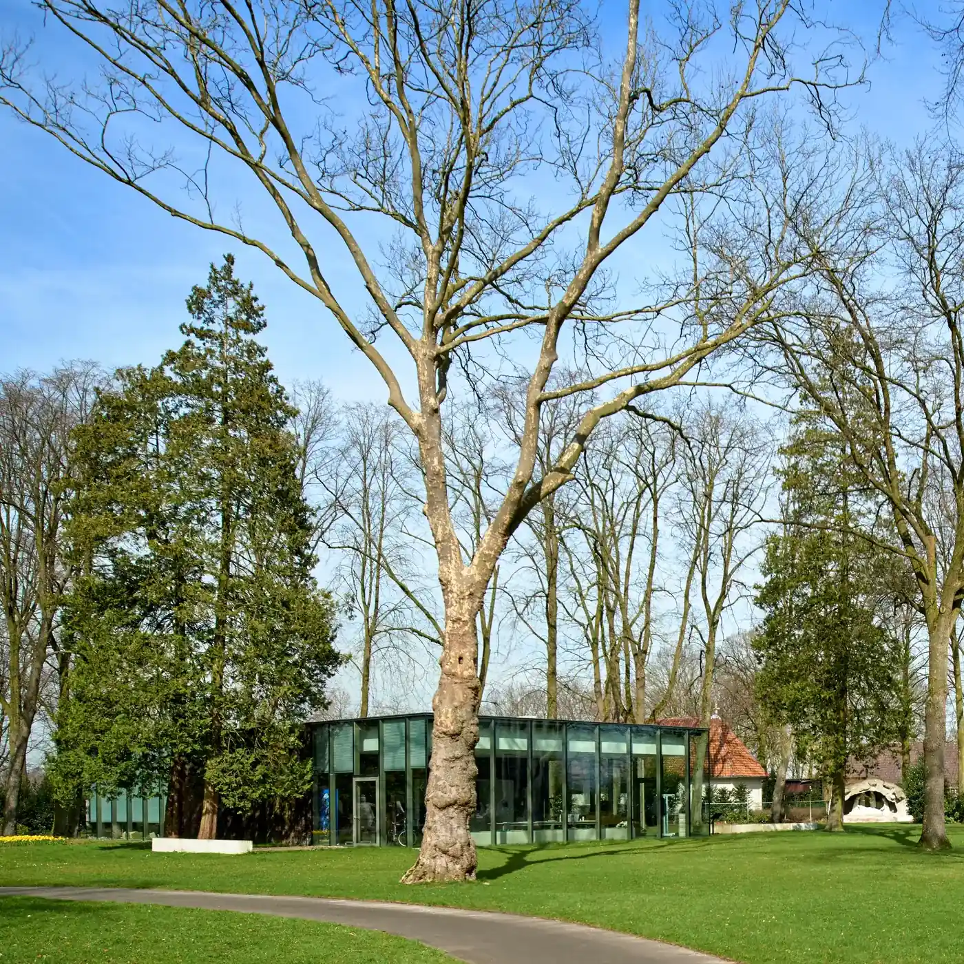Le pavillon Peerke Donders parmi les arbres du parc.