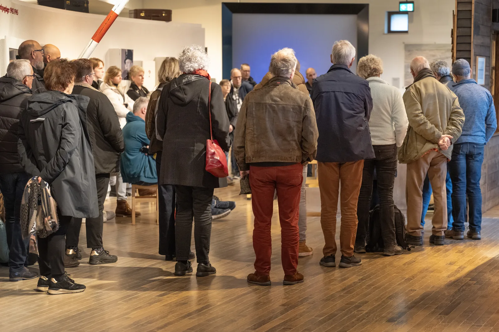 Group of visitors standing in a museum gallery.