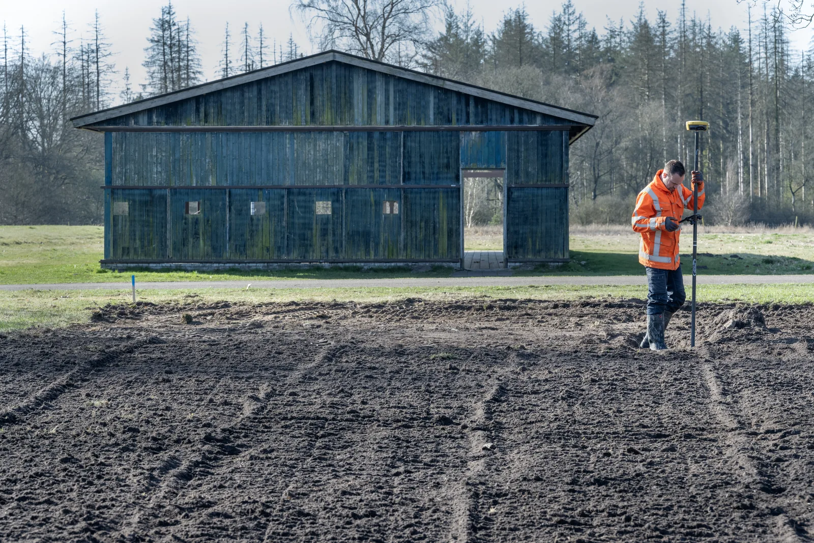 Worker near a wooden building on the grounds.