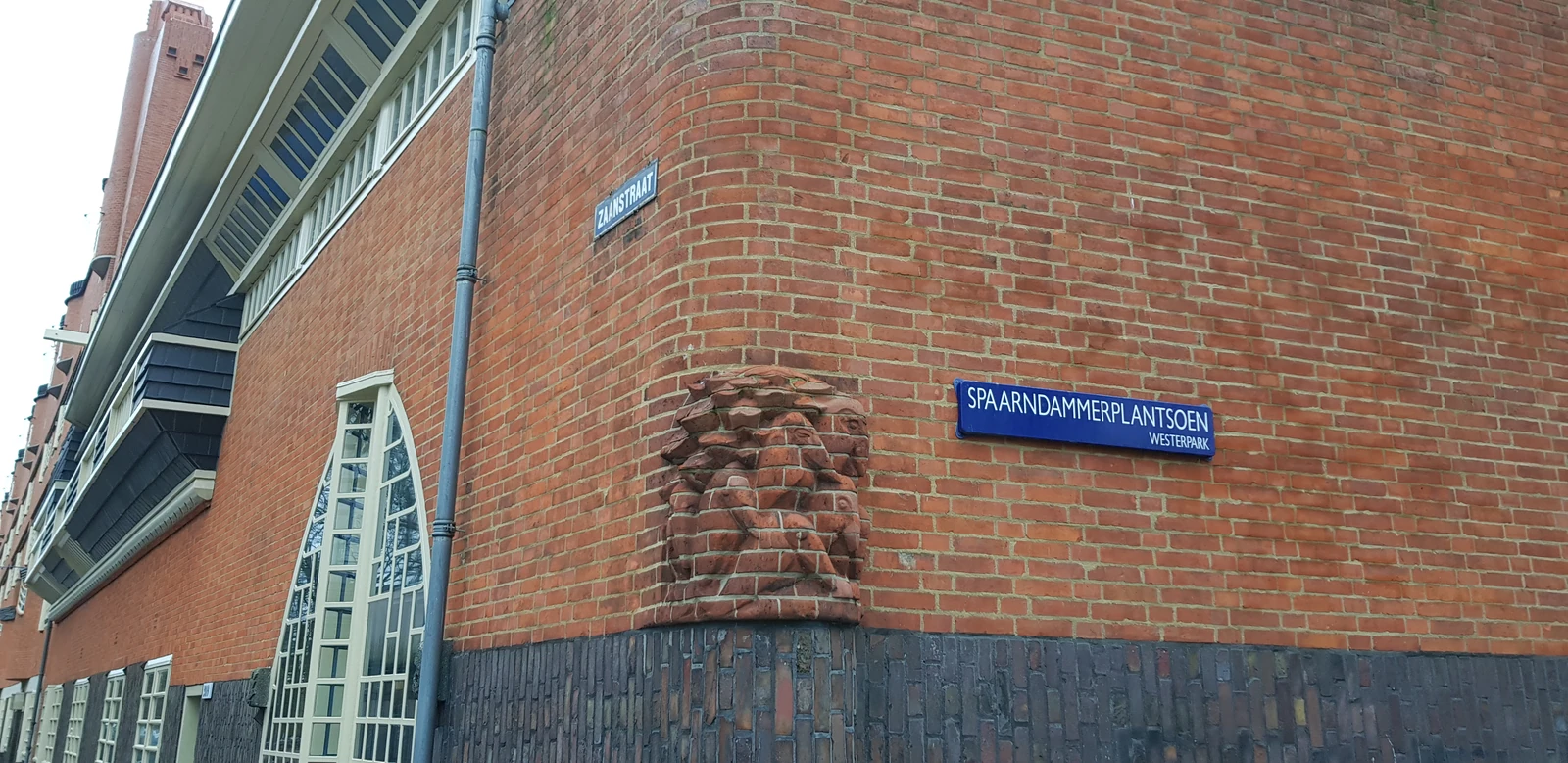 A brick corner of Het Schip with windows and street signs.