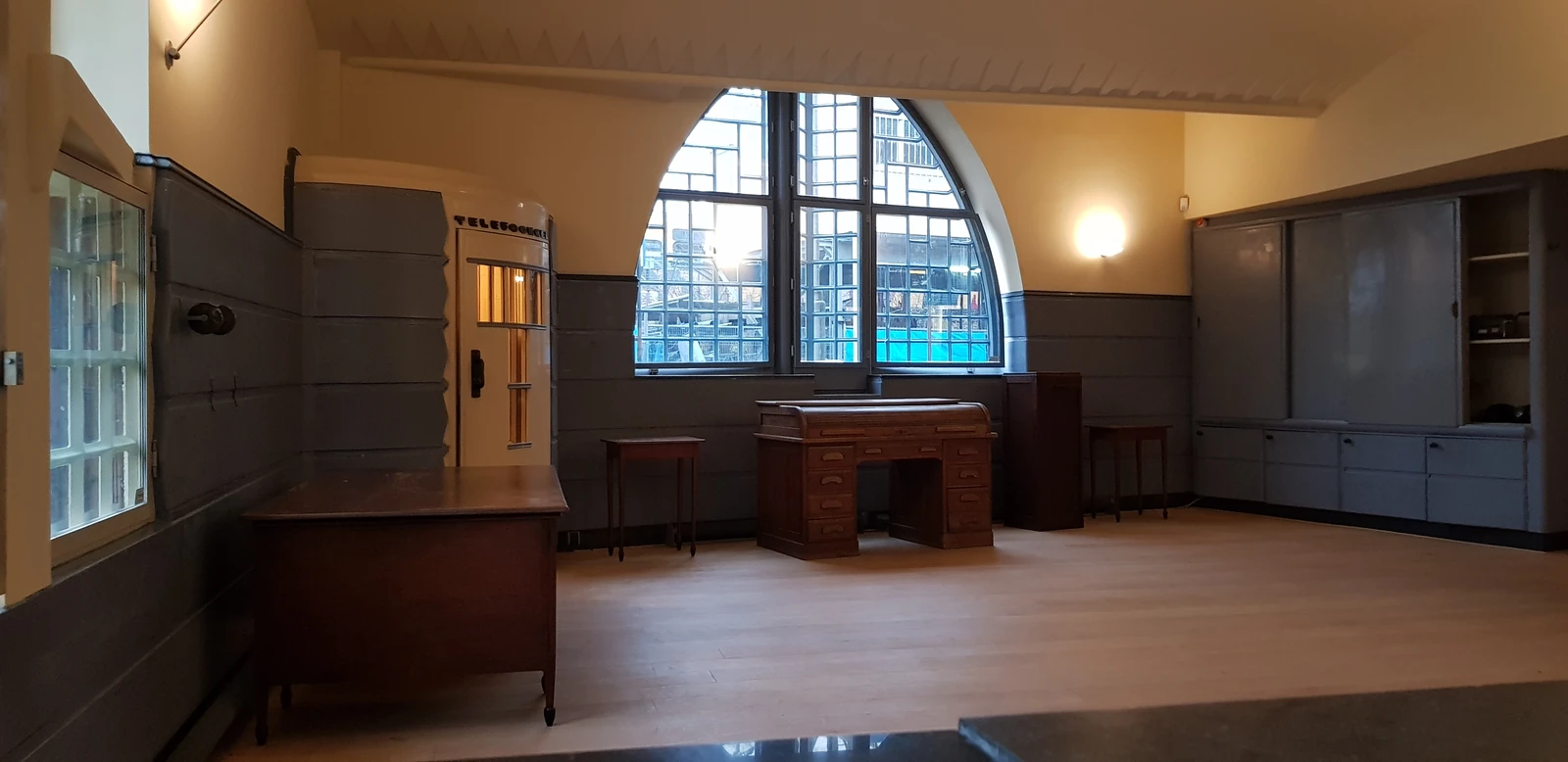 The former post office hall with a wooden counter and telephone booth.