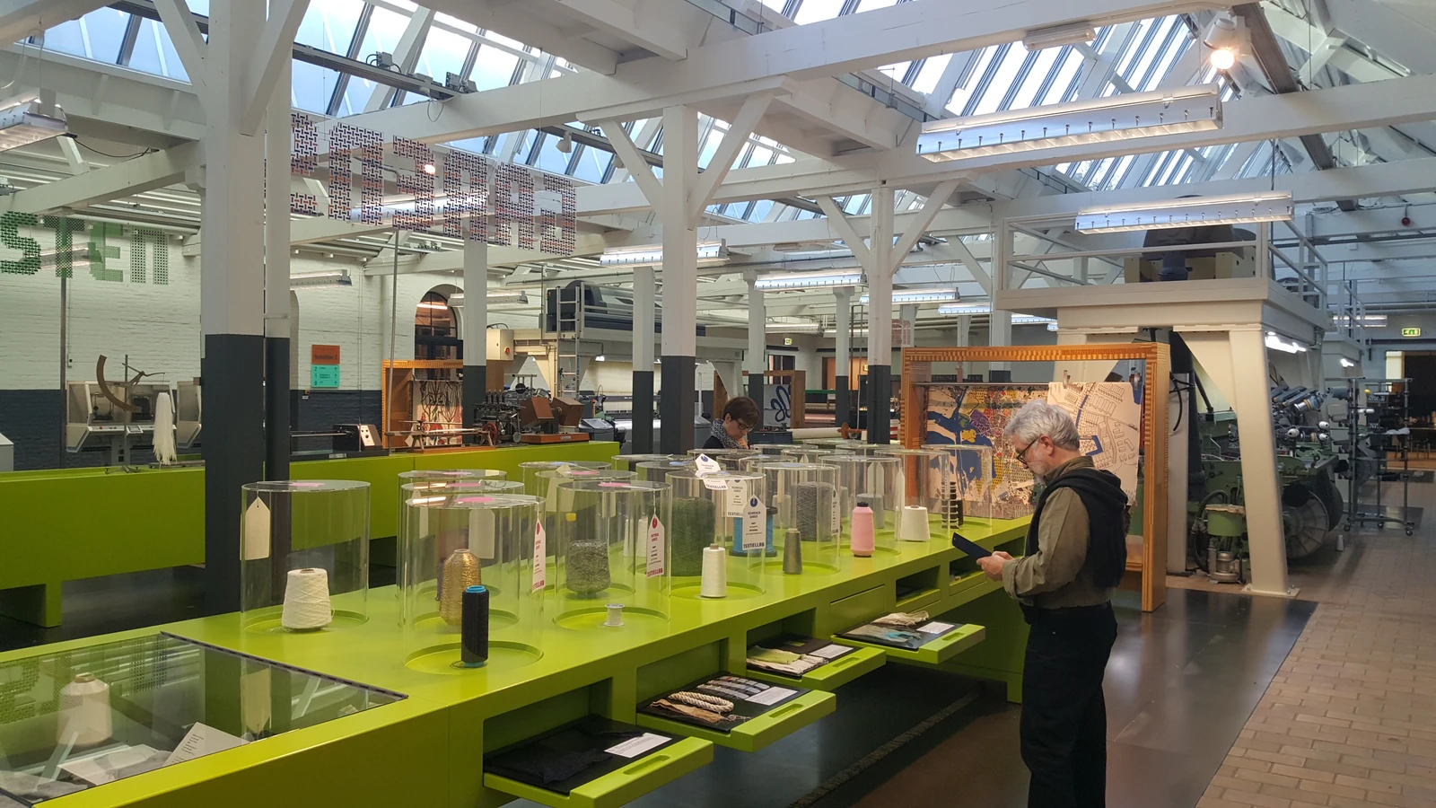 A bright exhibition space in the TextielMuseum with display cases.