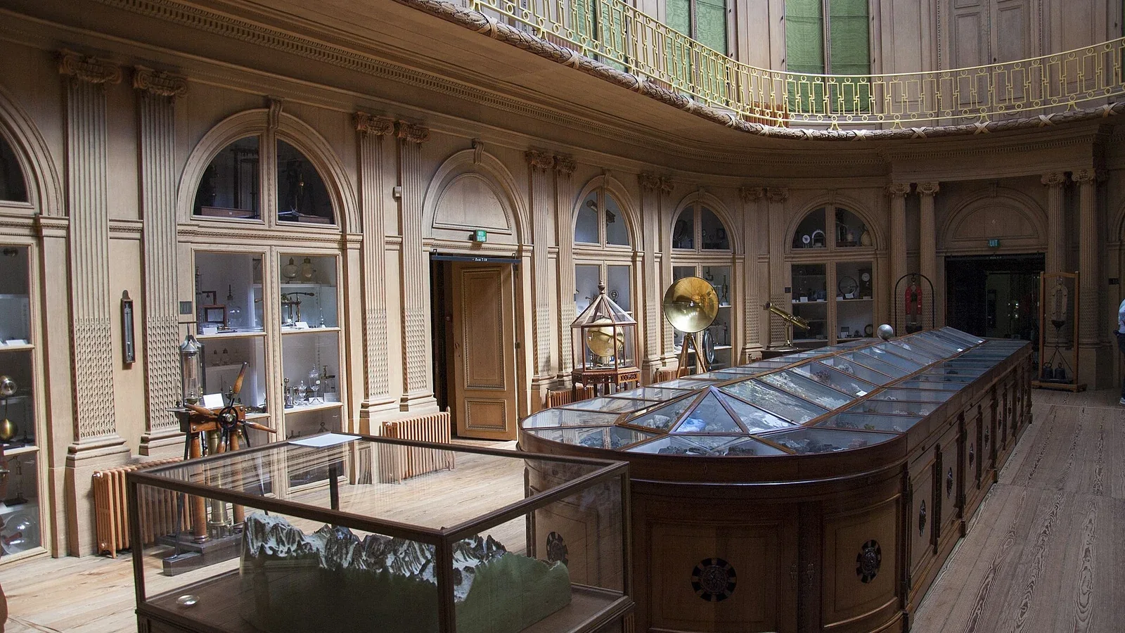 Oval Room of Teylers Museum with display cases and gallery.