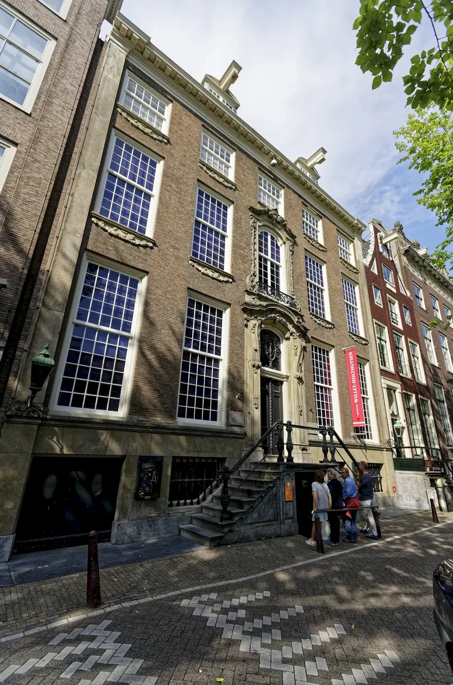 Wide canal house with tall windows, a stone entrance and a Museum Willet-Holthuysen sign.