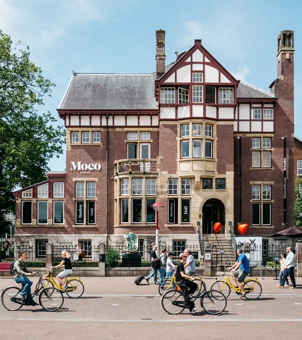 Brick villa with white half-timbering, bay windows and the Moco name beside the entrance.