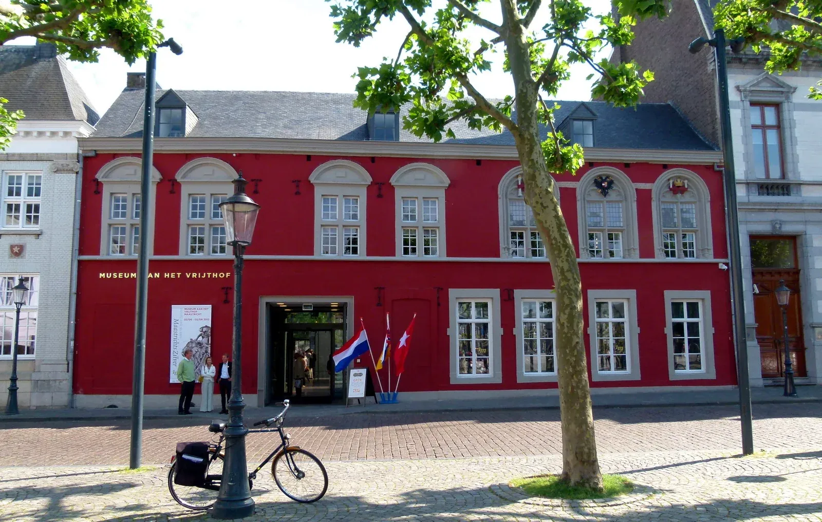 Red façade of the historic museum building on the Vrijthof with its former name.