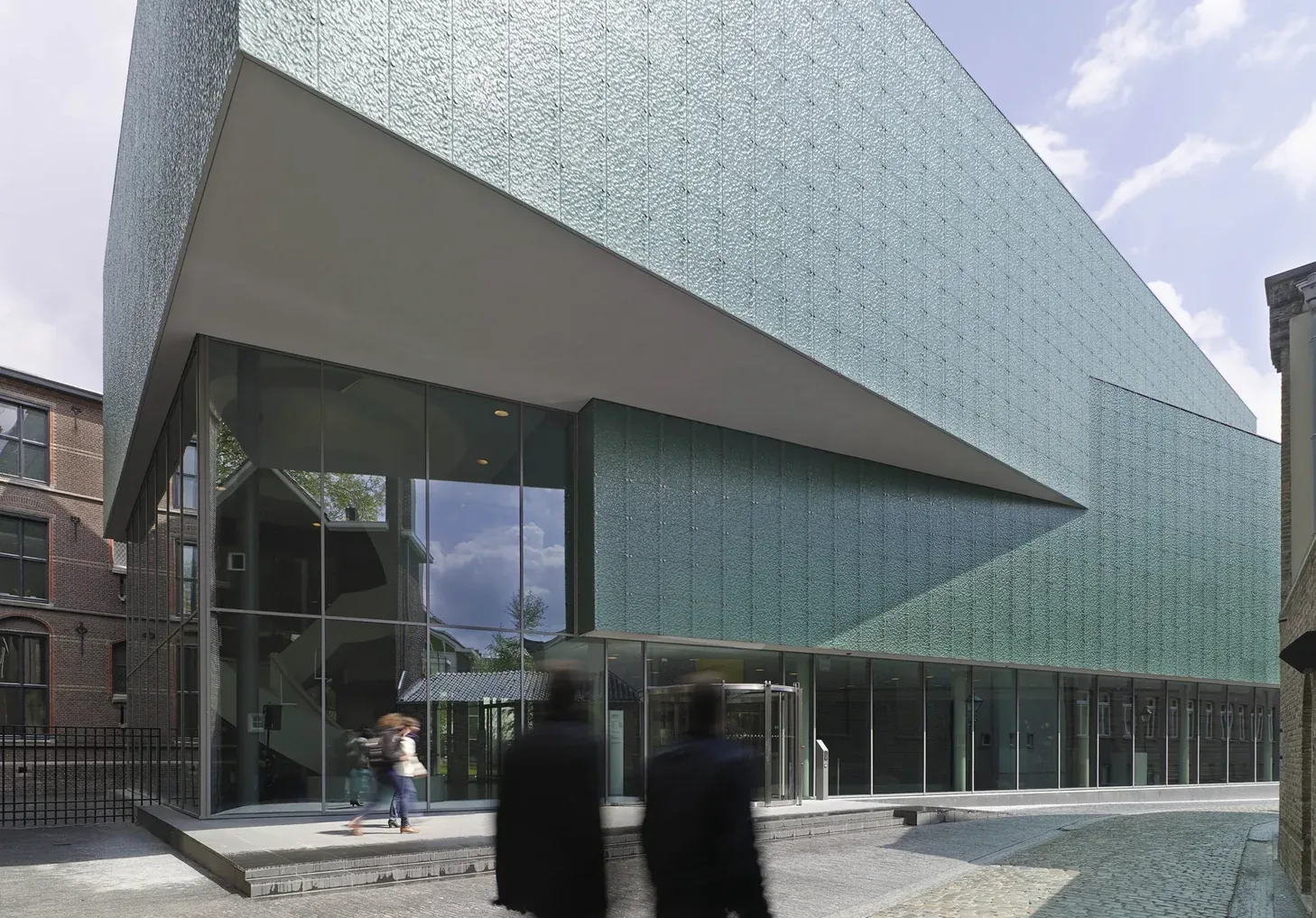 Modern museum building in Den Bosch with a glass ground floor and pale blue glass façade.