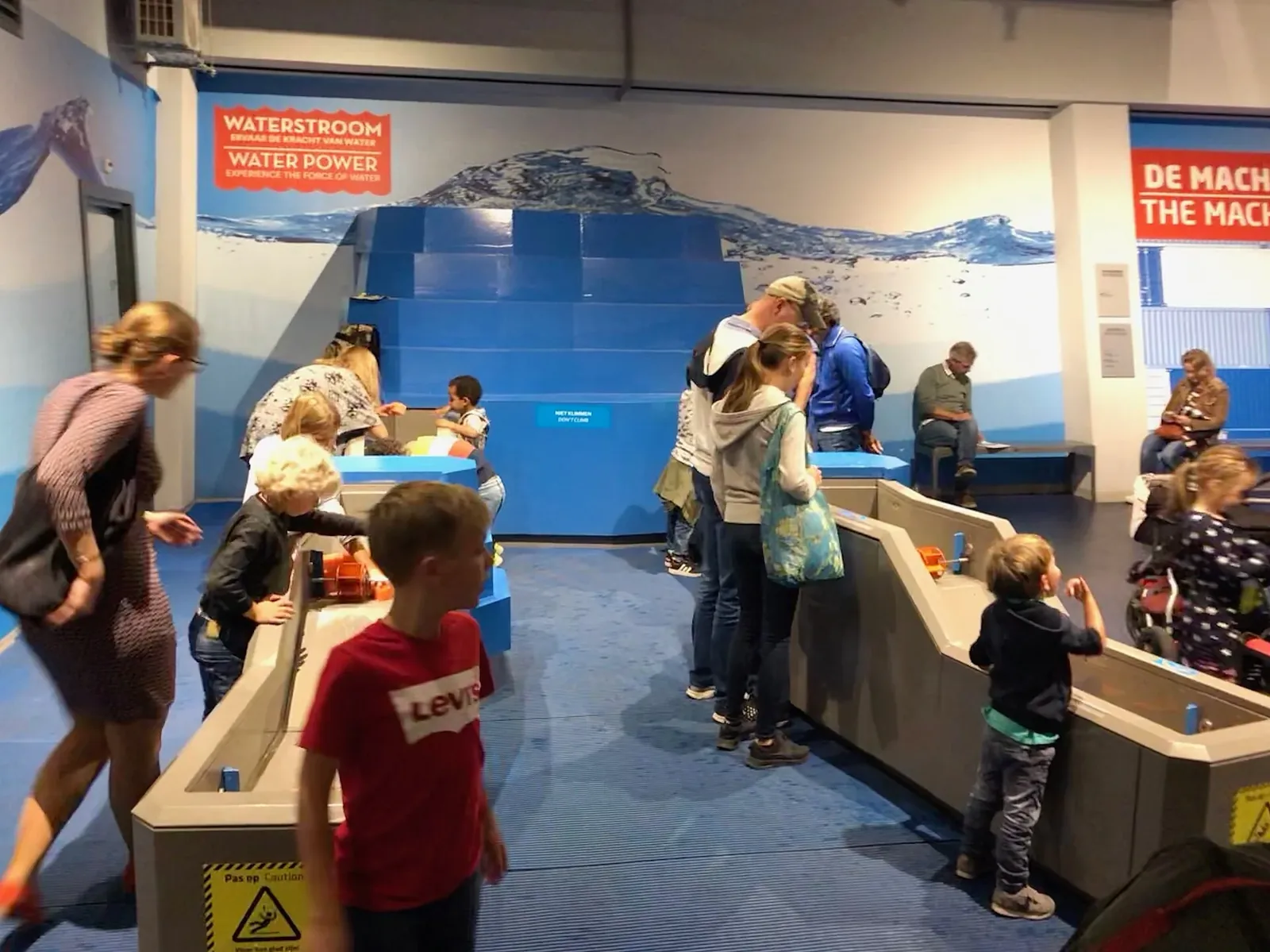 Besucher und Kinder an einer interaktiven Wasserstation im NEMO Science Museum.