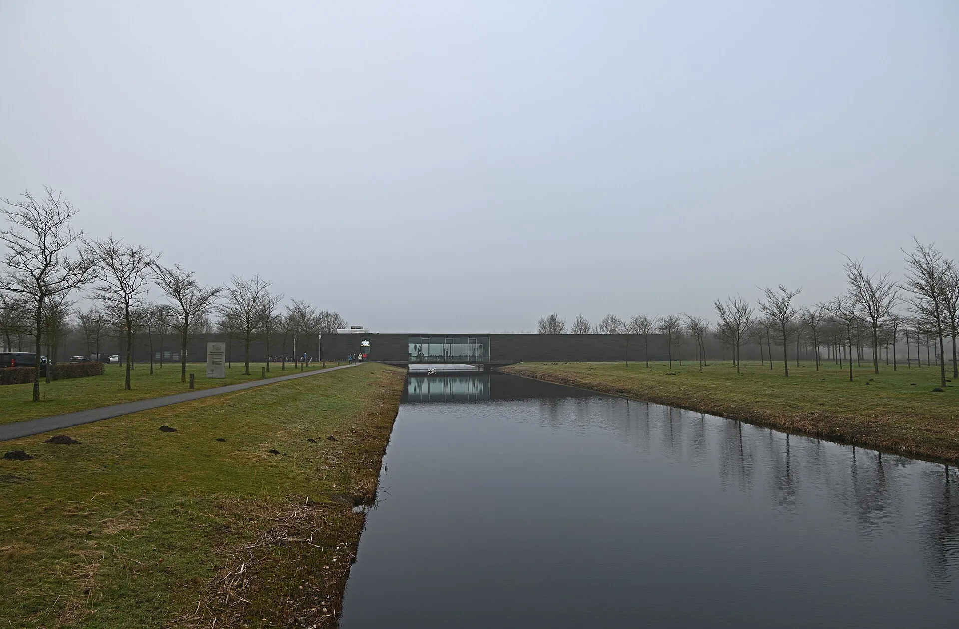 Langgerekt museumgebouw van Museum Belvédère aan het water in Oranjewoud.